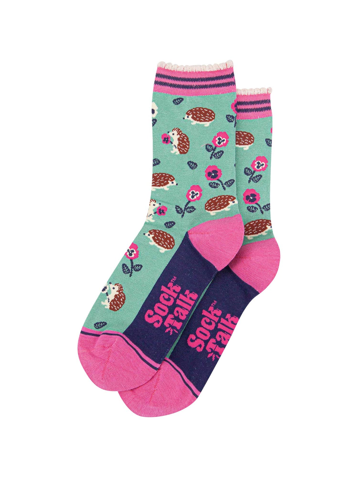 the pair of mint green hedgehog socks laying flat one overlapping the other. showing clearly the green background of the socks which is contrasted by the all over pattern of hedgehogs, flowers and leaves. the sock talk logo is pink and visible on the base of the sole.