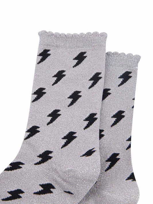 light grey cotton ankle socks with an all over black lightning bolt print pattern and silver glitter shimmer, the socks have scalloped cuffs