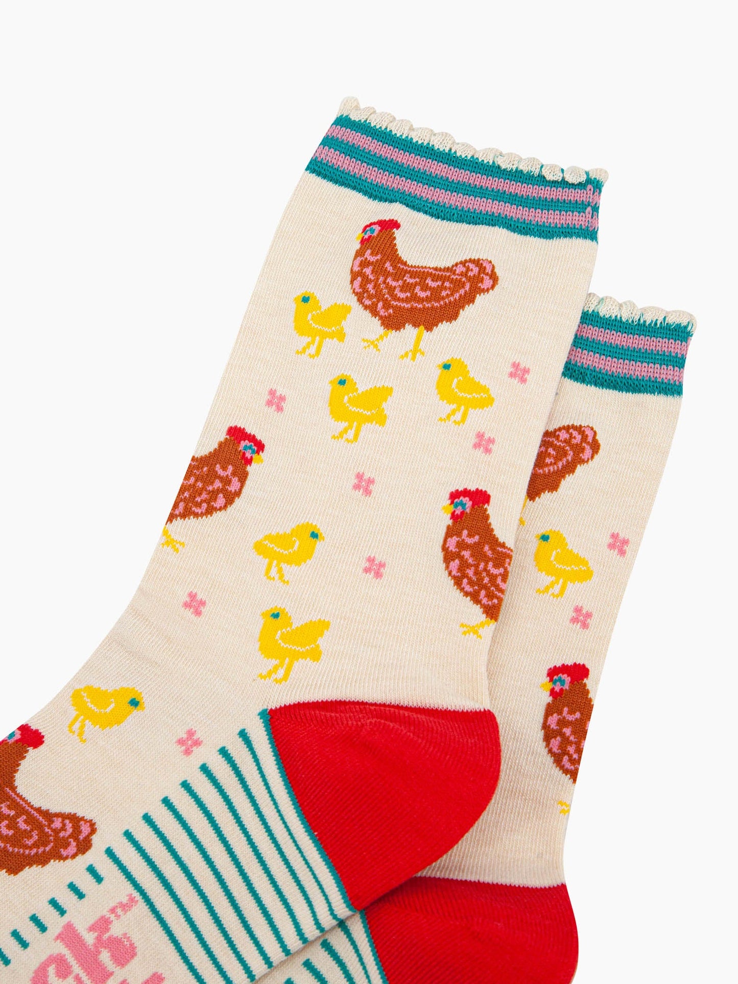 close up of the pattern. the mother hens are brown and are surrounded by small yellow baby chicks. there are small pink flowers scattered around the design.