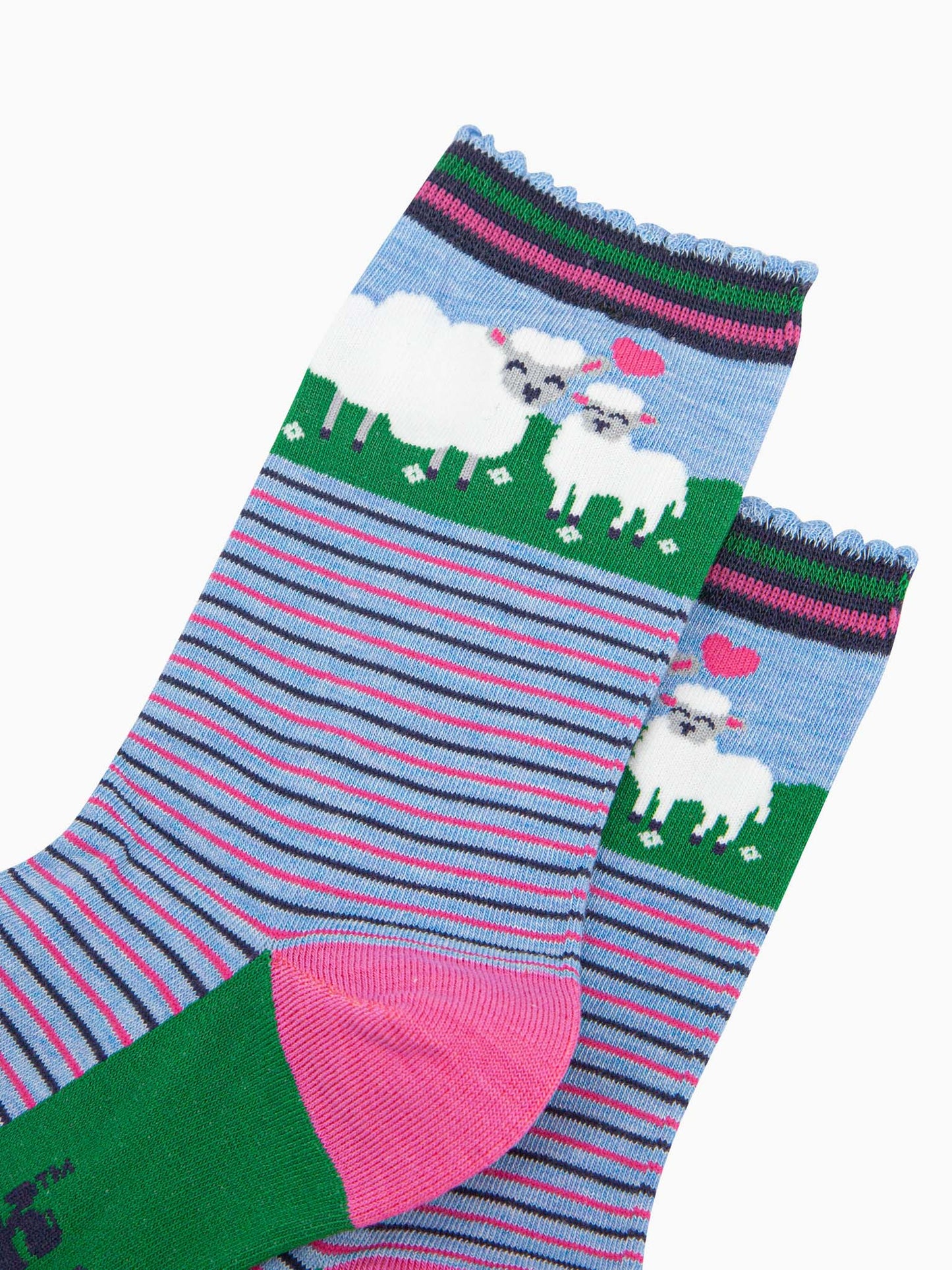 close up of the pattern, the ankle part of the socks features a white sheep and a baby lamb. between the animals is a pink love heart. the cuff of the socks is scalloped and has a pink and green stiped pattern.