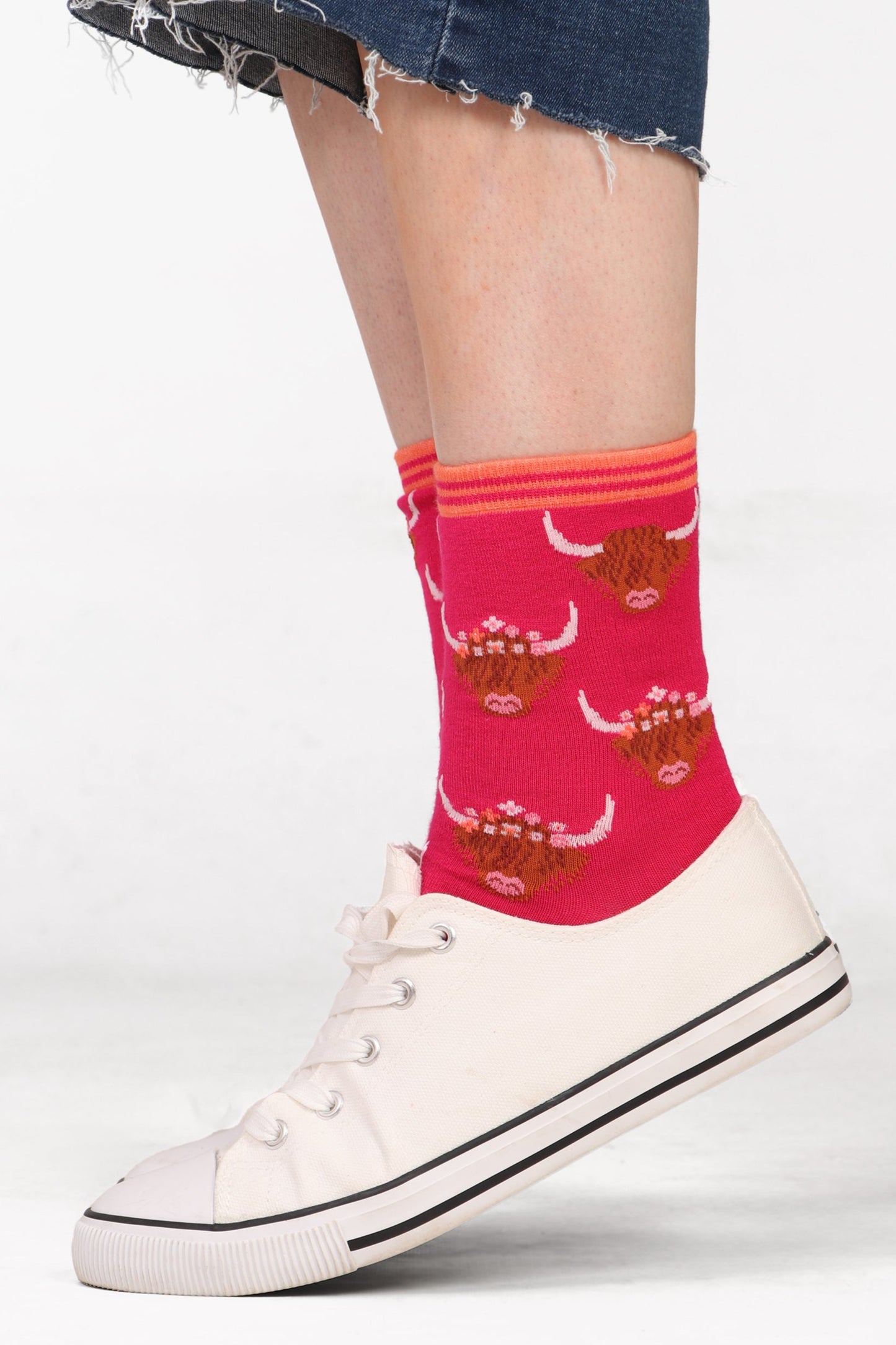 Model wearing cropped jeans with womens bamboo socks in a highland cow wearing flower crown print