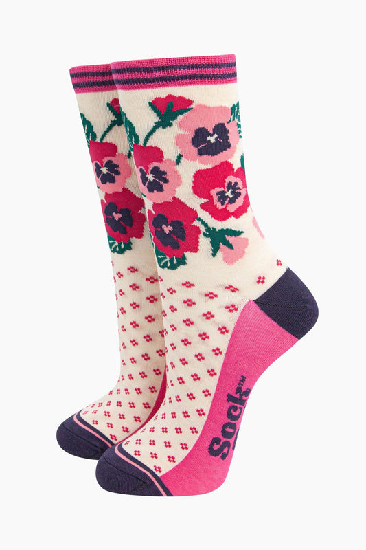 cream bamboo socks with a navy blue heel and toe and fuchsia pink sole. the ankle of the socks is covered with a fuchsia pink and light pink pansy flower arrangement.