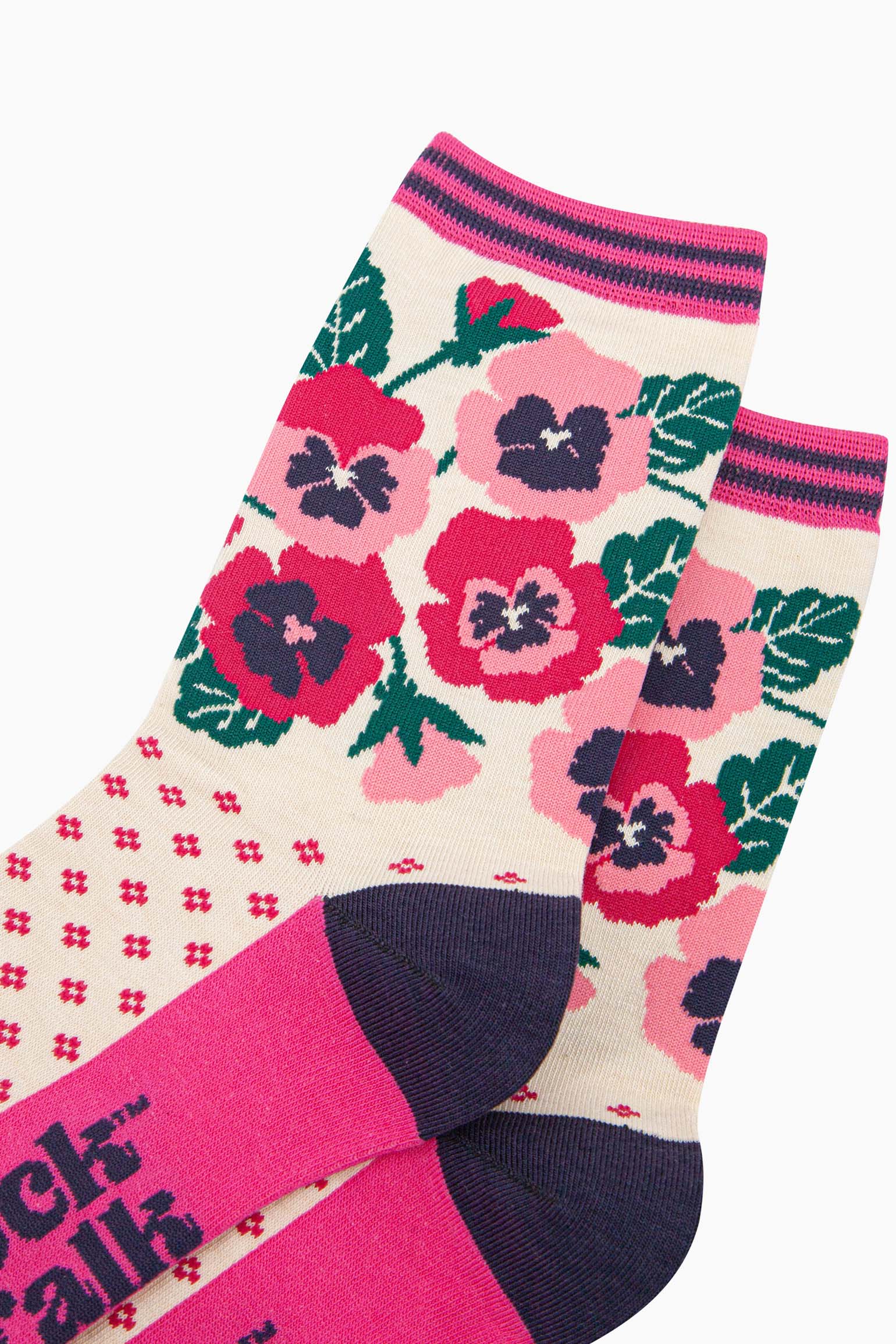 close up of the design. the pansy flowers are fuchsia pink and light pink. they are shown in full bloom and partial bud from. the arrangement of flowers is complemented by green leaves.