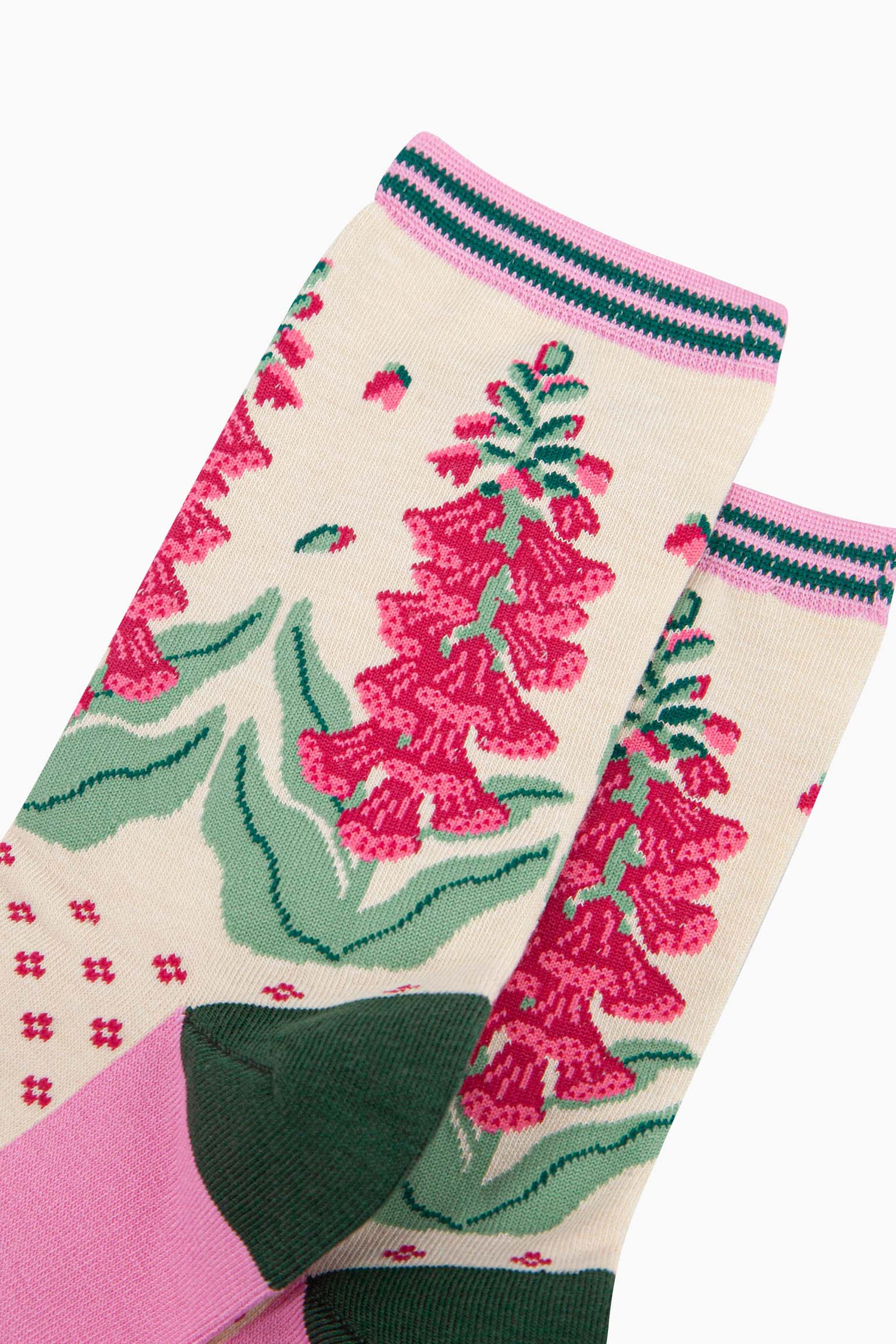 close up of the pattern. shown on the ankle are foxglove plants in full bloom. the flowers are fuchsia pink and they are shedding a few petals.