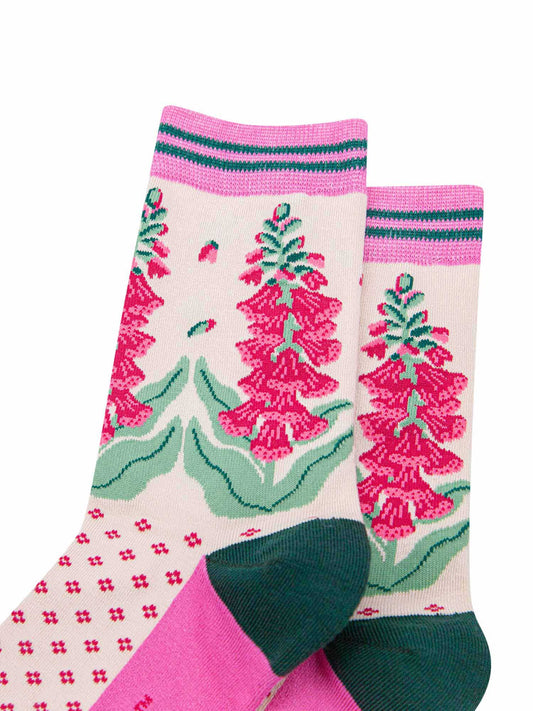 close up of the pattern. shown on the ankle are foxglove plants in full bloom. the flowers are fuchsia pink and they are shedding a few petals.