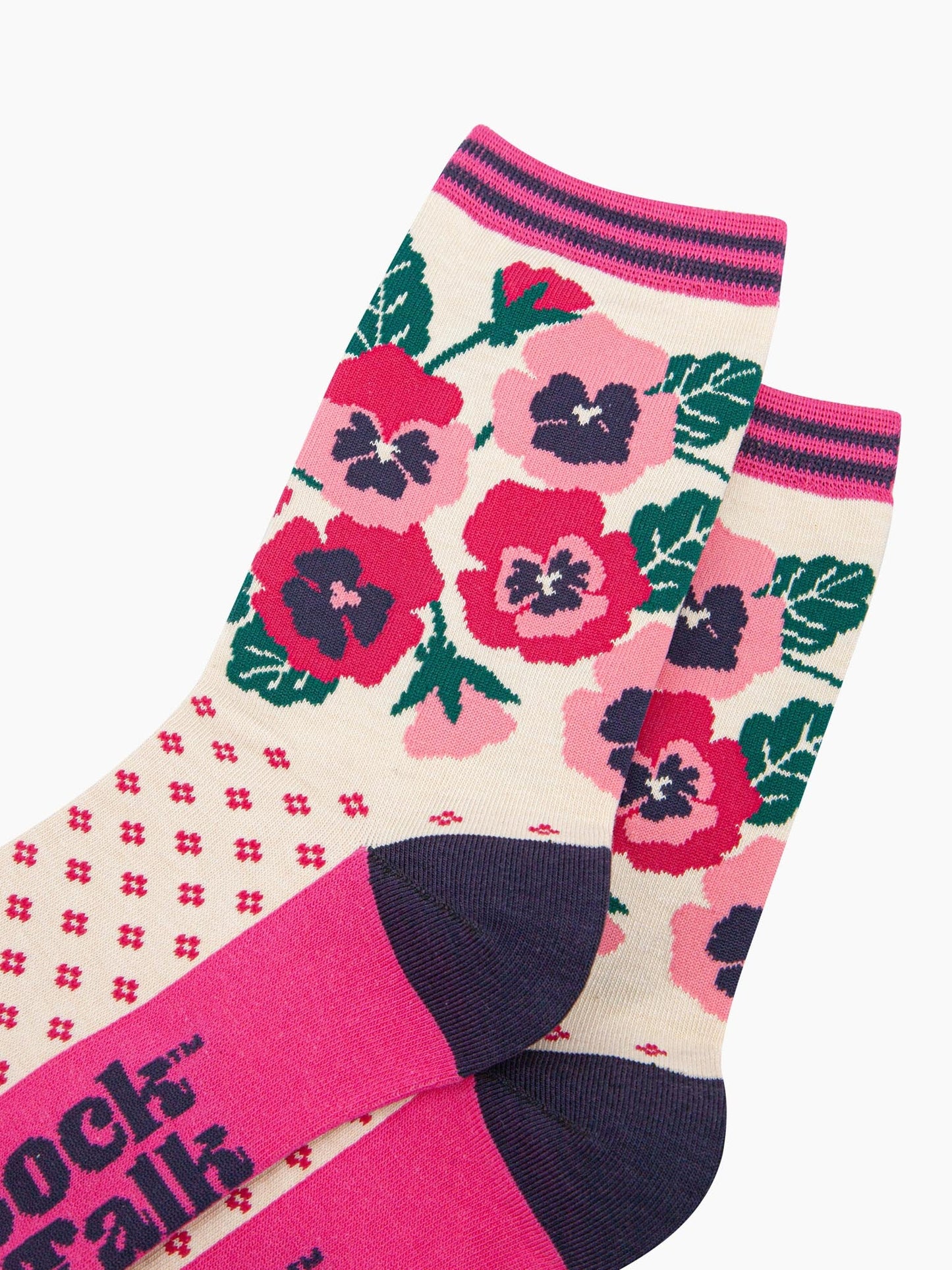 close up of the design. the pansy flowers are fuchsia pink and light pink. they are shown in full bloom and partial bud from. the arrangement of flowers is complemented by green leaves.