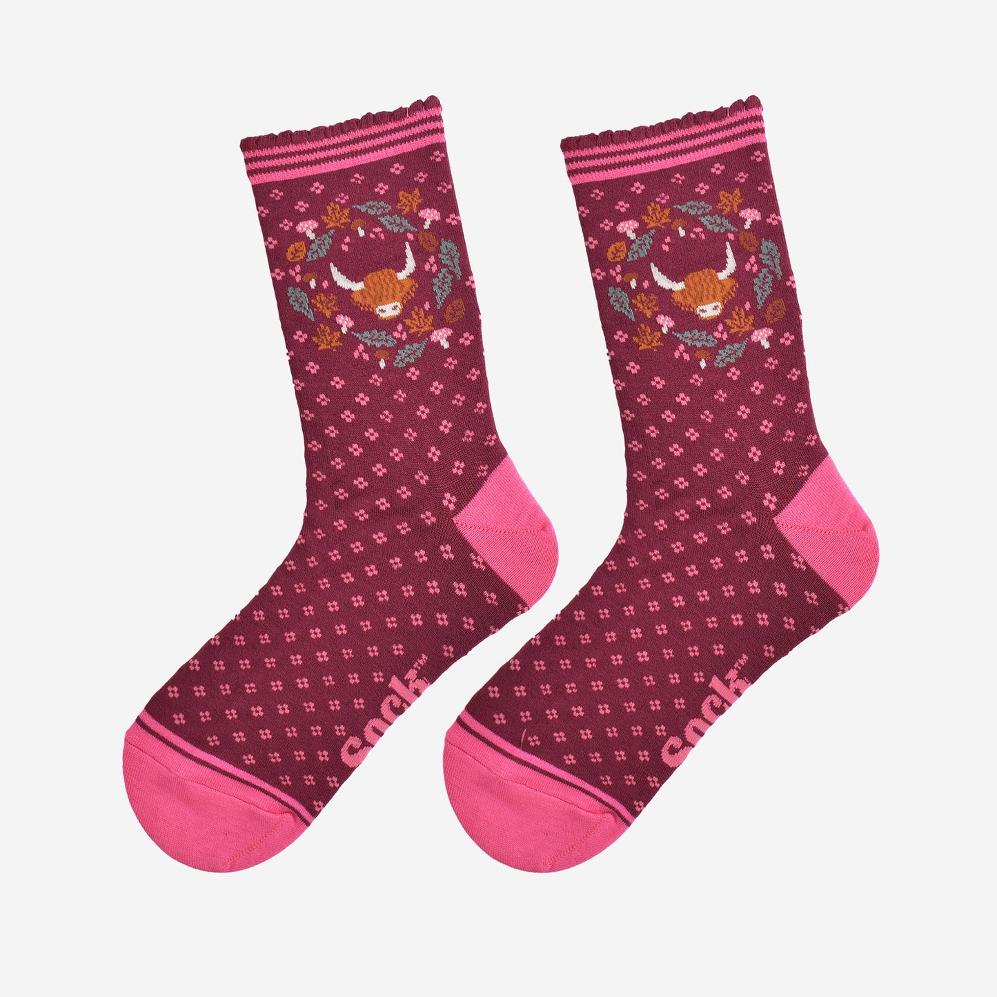 highland cow wreath bamboo socks laying flat, showing burgundy socks with an all over pink floral pattern and a highland cow surrounded by autumn foliage on the ankles