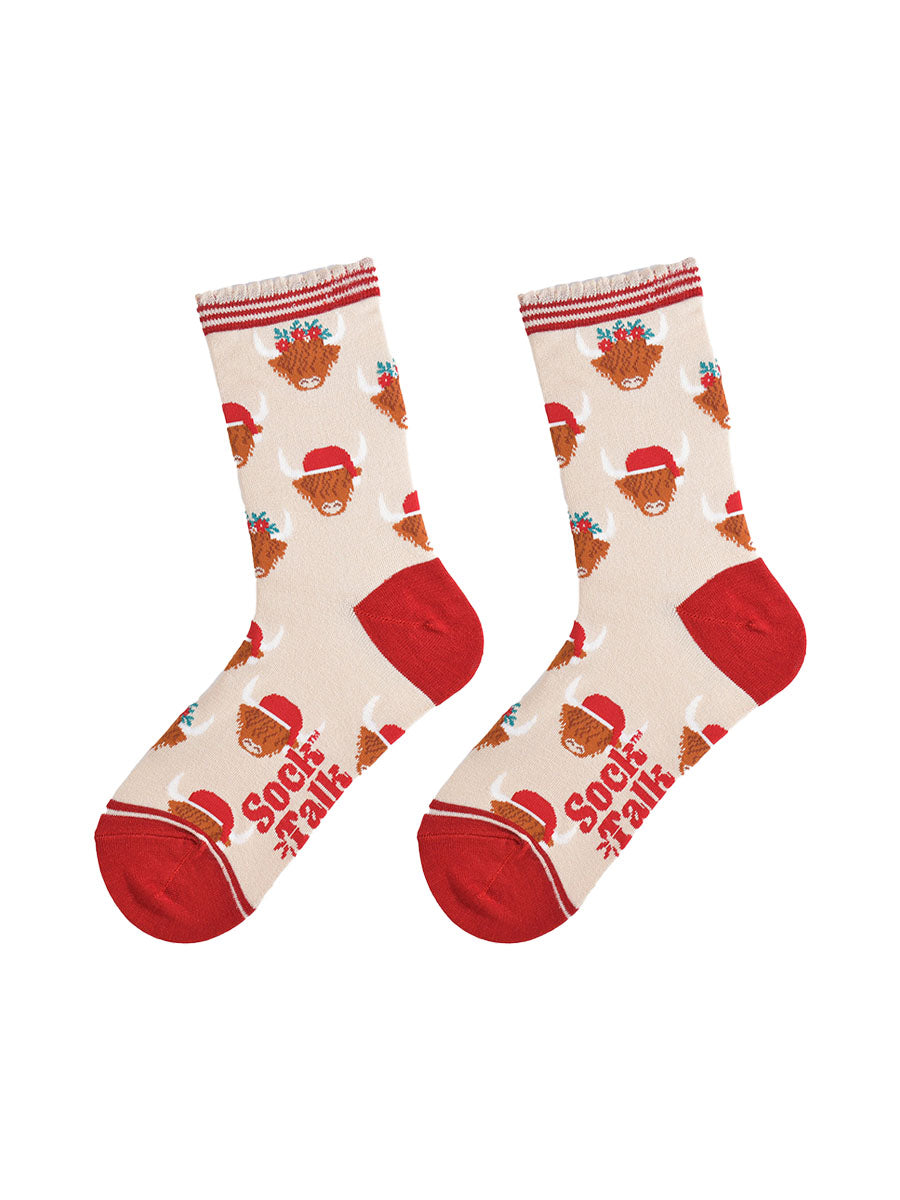 cream and red highland cow bamboo socks laying flat, showing the all over pattern of highland cows wearing santa hats and festive garlands