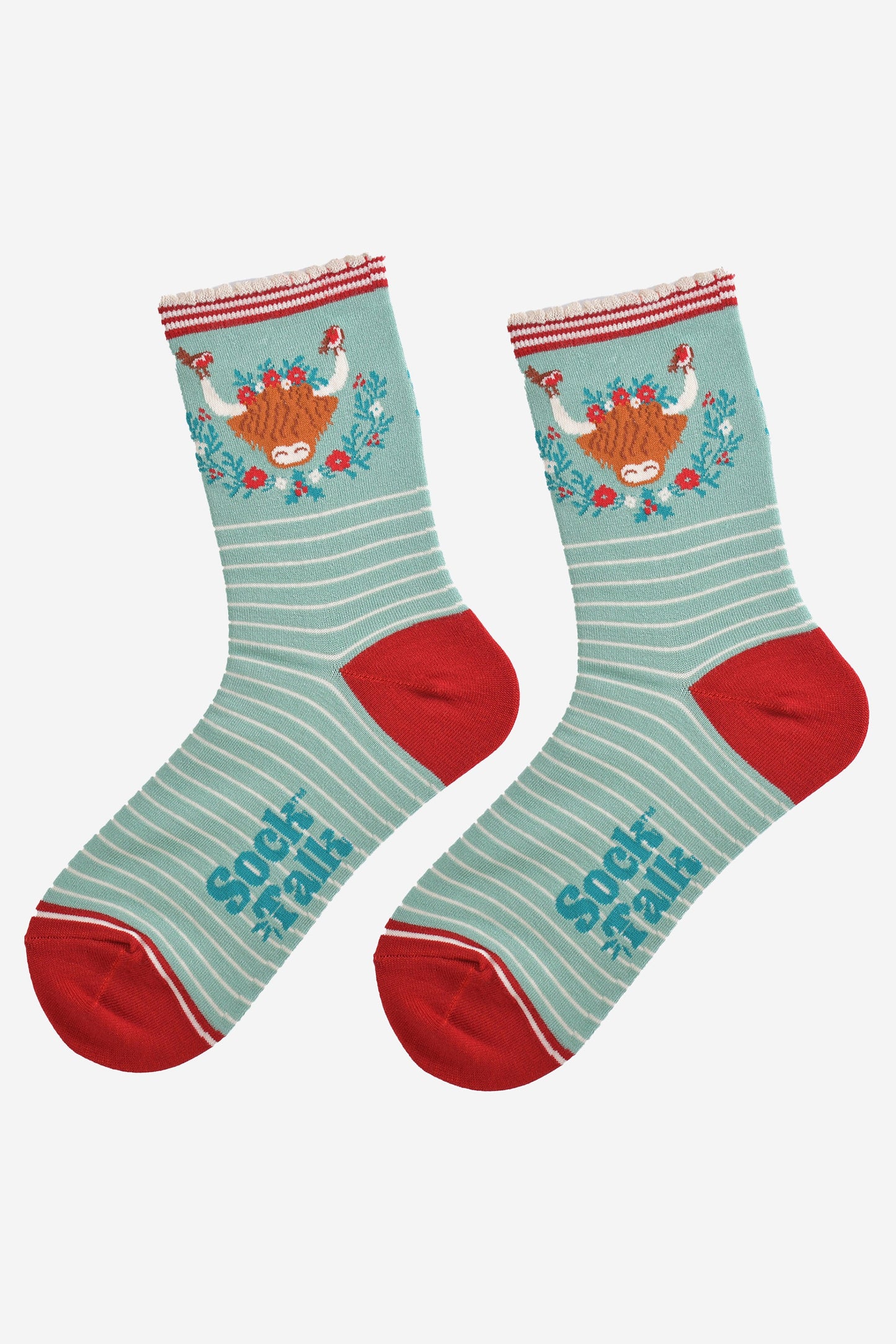 showing the socks laying flat, highlighting the white pinstripe pattern and large highland cow and wreath design on the ankle of the socks