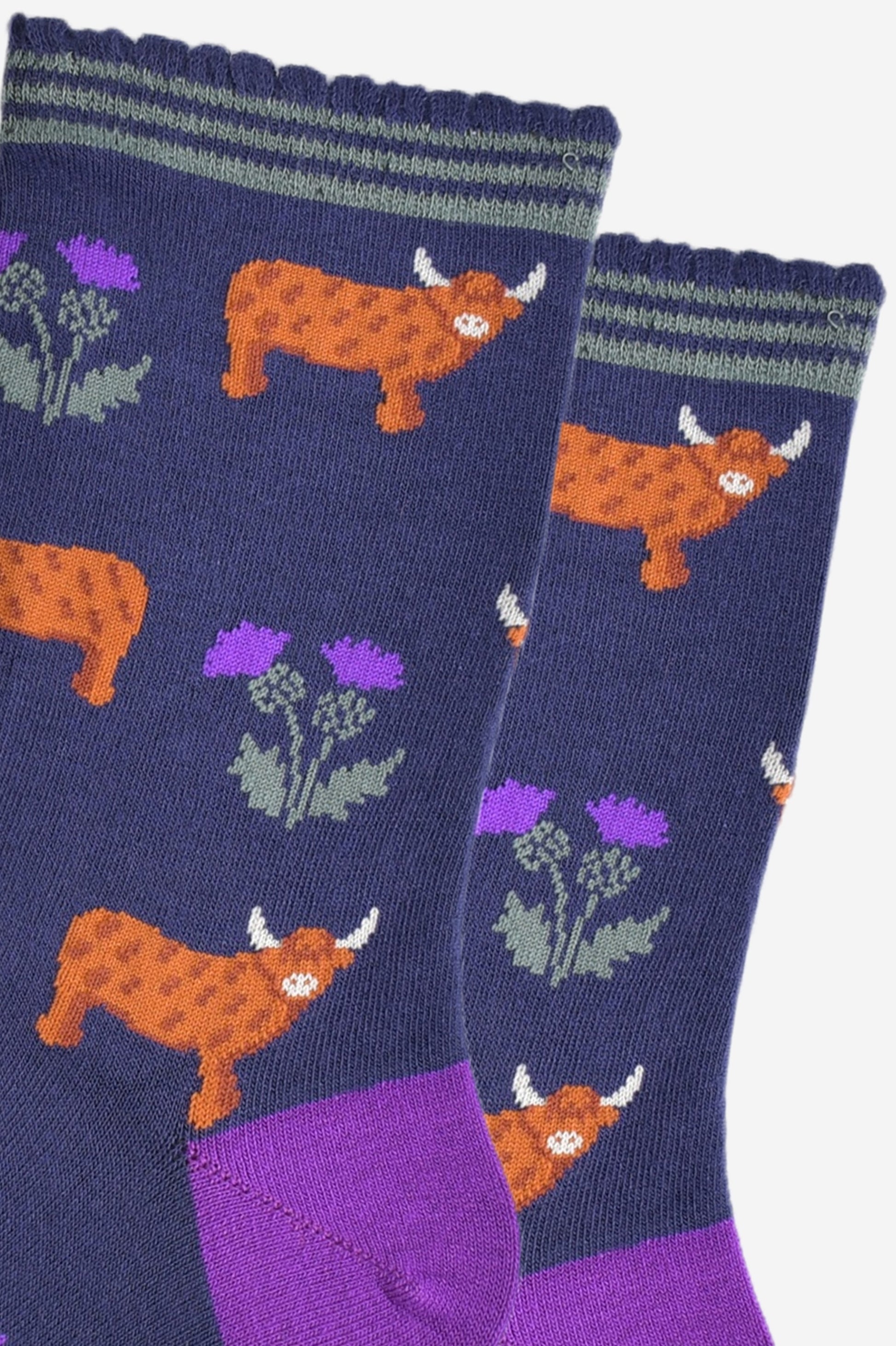close up of the highland cow and thistle pattern, the highland cows are standing in profile  and the thistles are twin headed