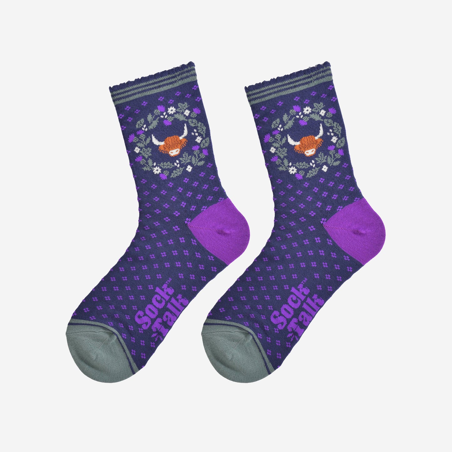 highland cow and wreath bamboo socks laying flat, showing the all over purple spotted pattern, green and purple thistle flower wreath and highland cow