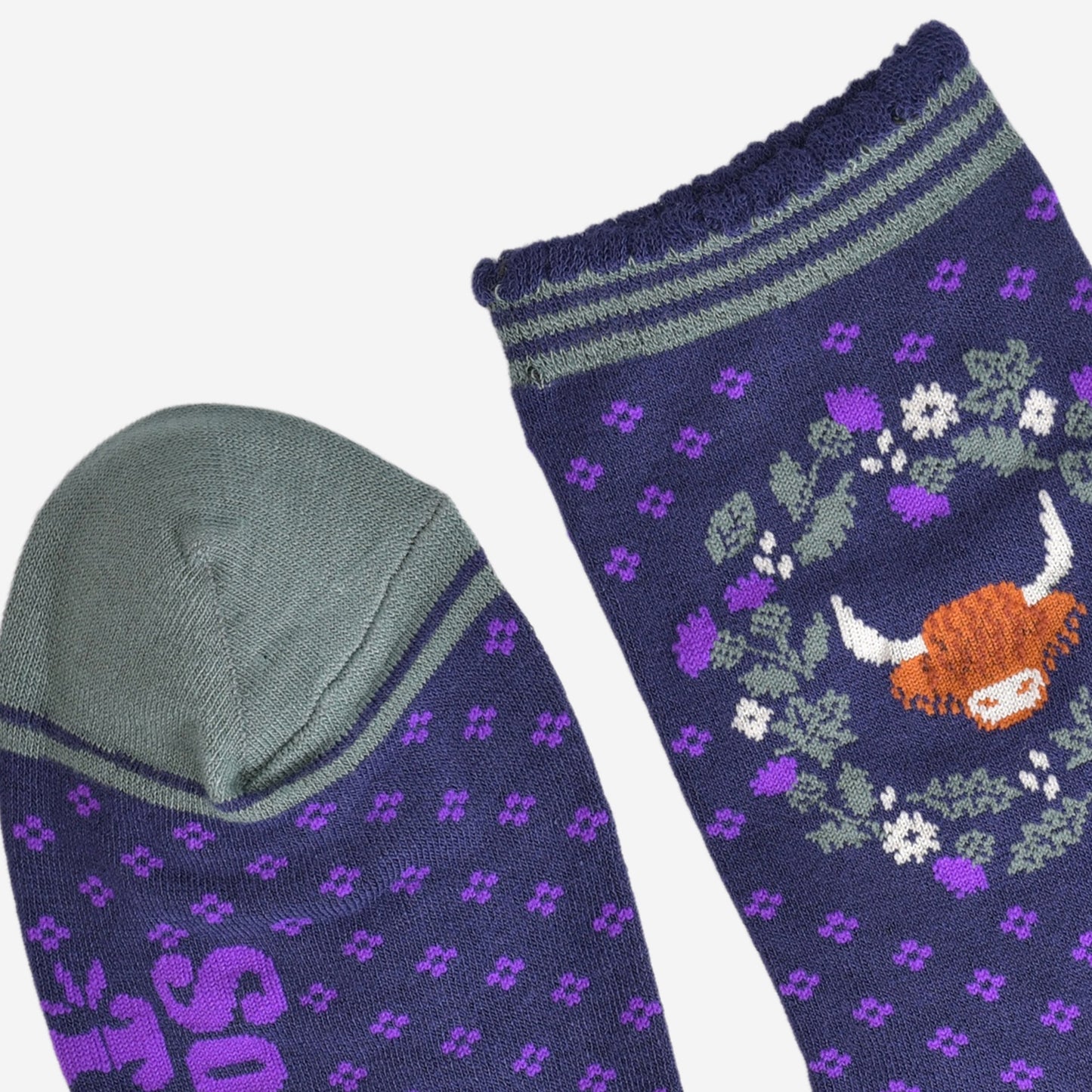 close up of the cuff and toe of the socks, the toe is green and the cuff had three green thin horizontal stripes and a scalloped edge