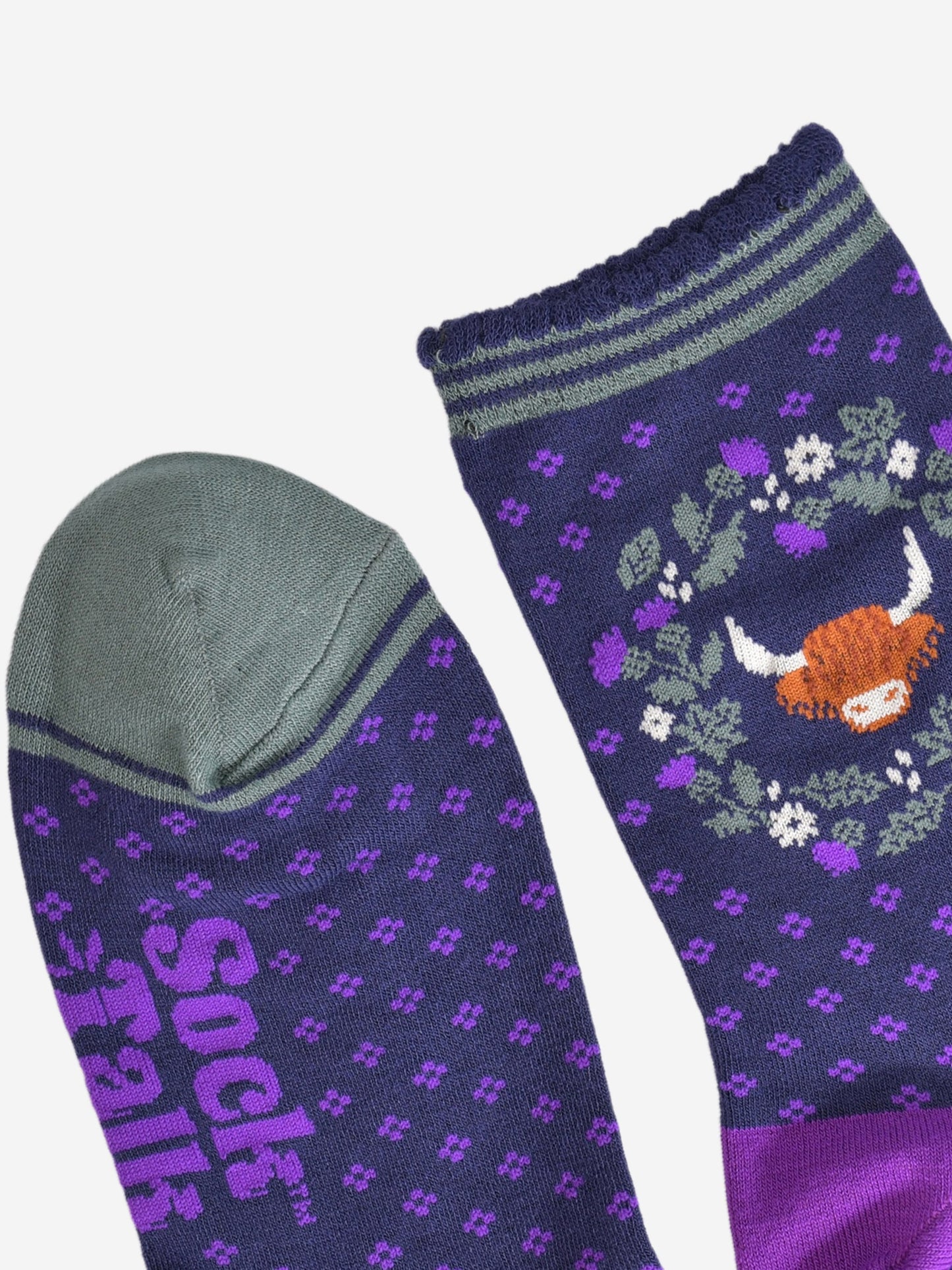 close up of the cuff and toe of the socks, the toe is green and the cuff had three green thin horizontal stripes and a scalloped edge