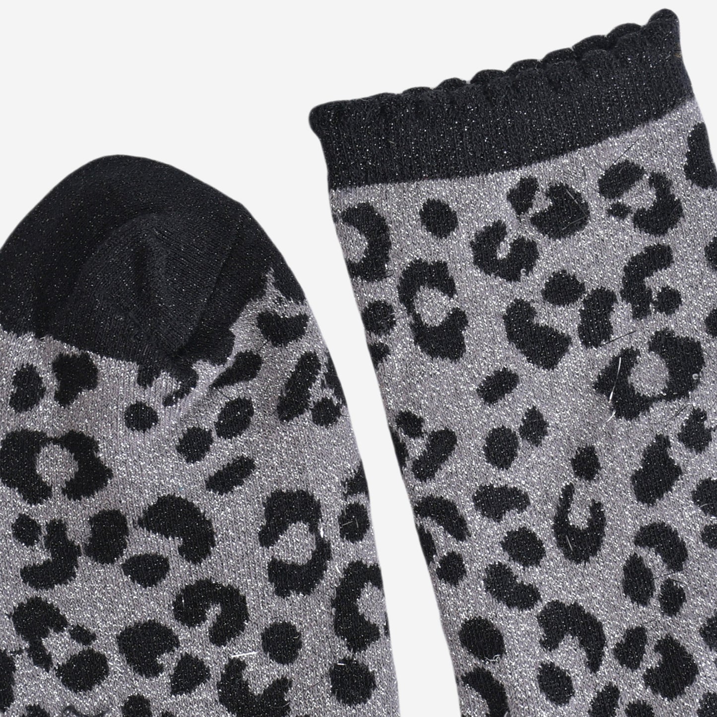 showing the toe and cuff of the socks, the toe is black and sparkly like the black leopard print pattern, the cuff is also black and sparkly and has a scalloped edge