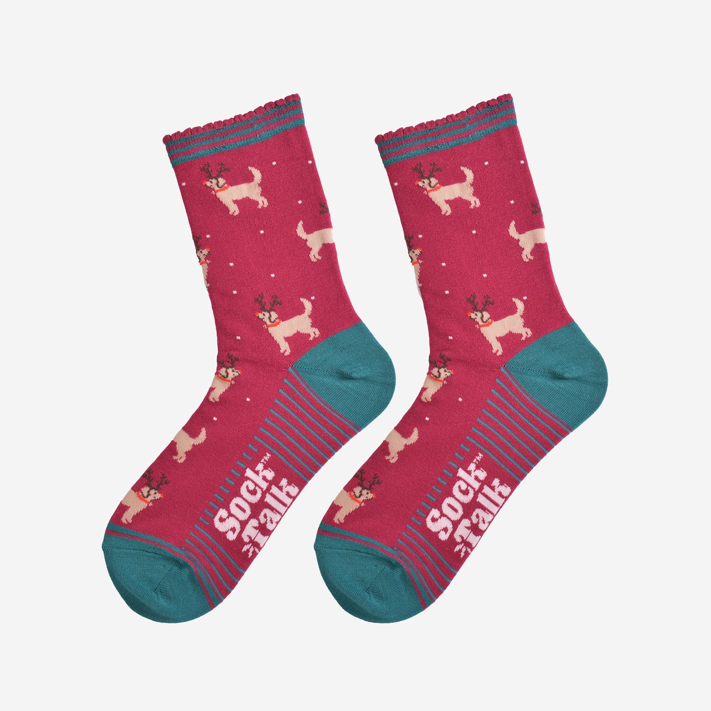 showing the golden retriever socks laying flat, the soles have green stripes, the dog pattern is all over the socks and there are also subtle falling snowflakes.