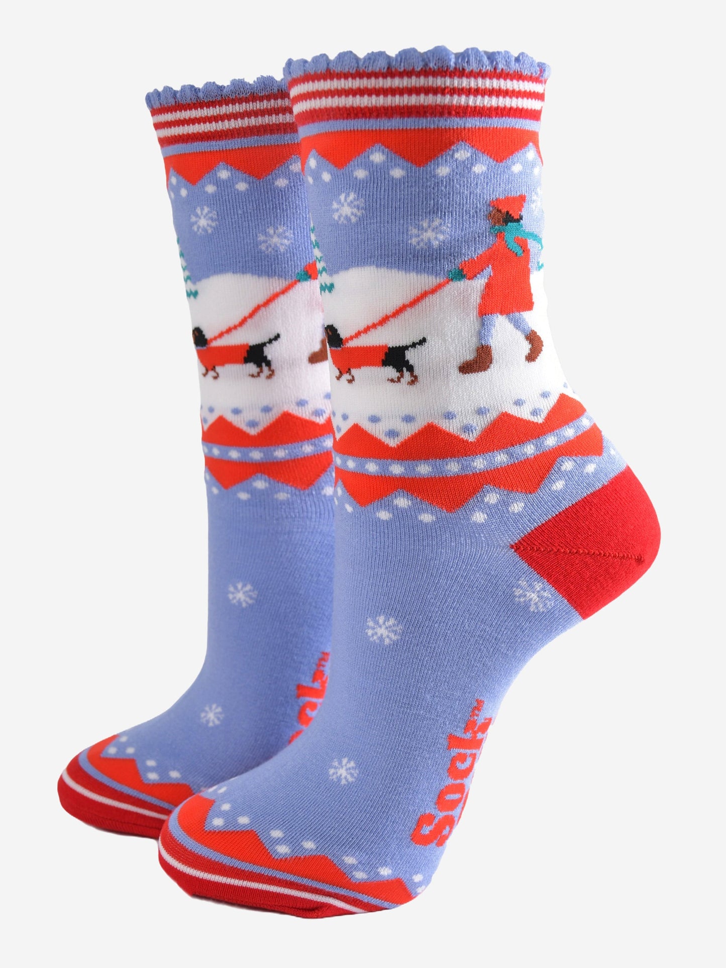 blue and red bamboo socks with a winter scene, showing a sausage dog and its owner taking a walk in the snow.