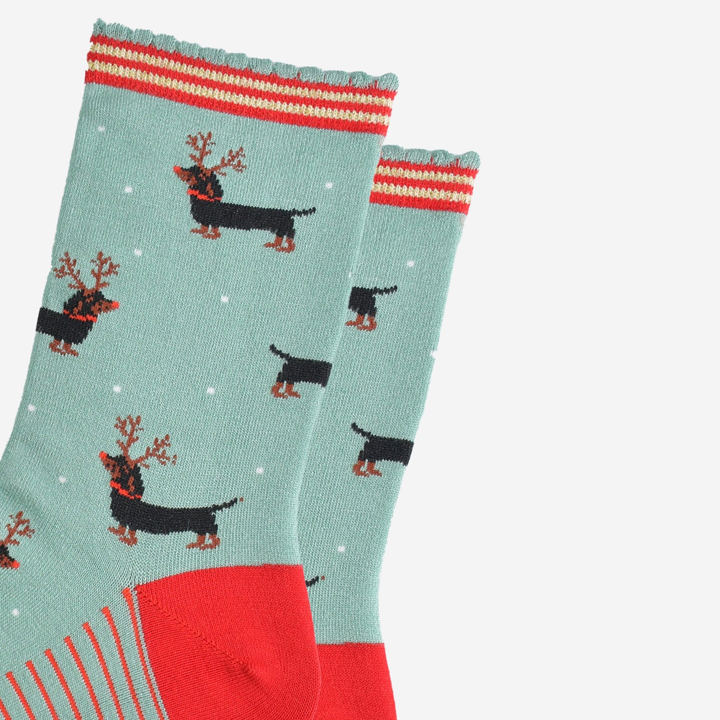 close up of the sausage dog pattern, the dogs are black and tan, traditional markings, they are wearing a set of brown reindeer antlers and wearing red noses like rudolph.