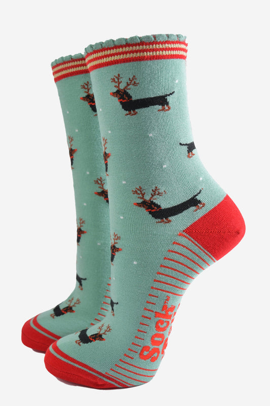 green and red ankle socks with a scalloped cuff and a pattern of dachshund dogs wearing reindeer antlers