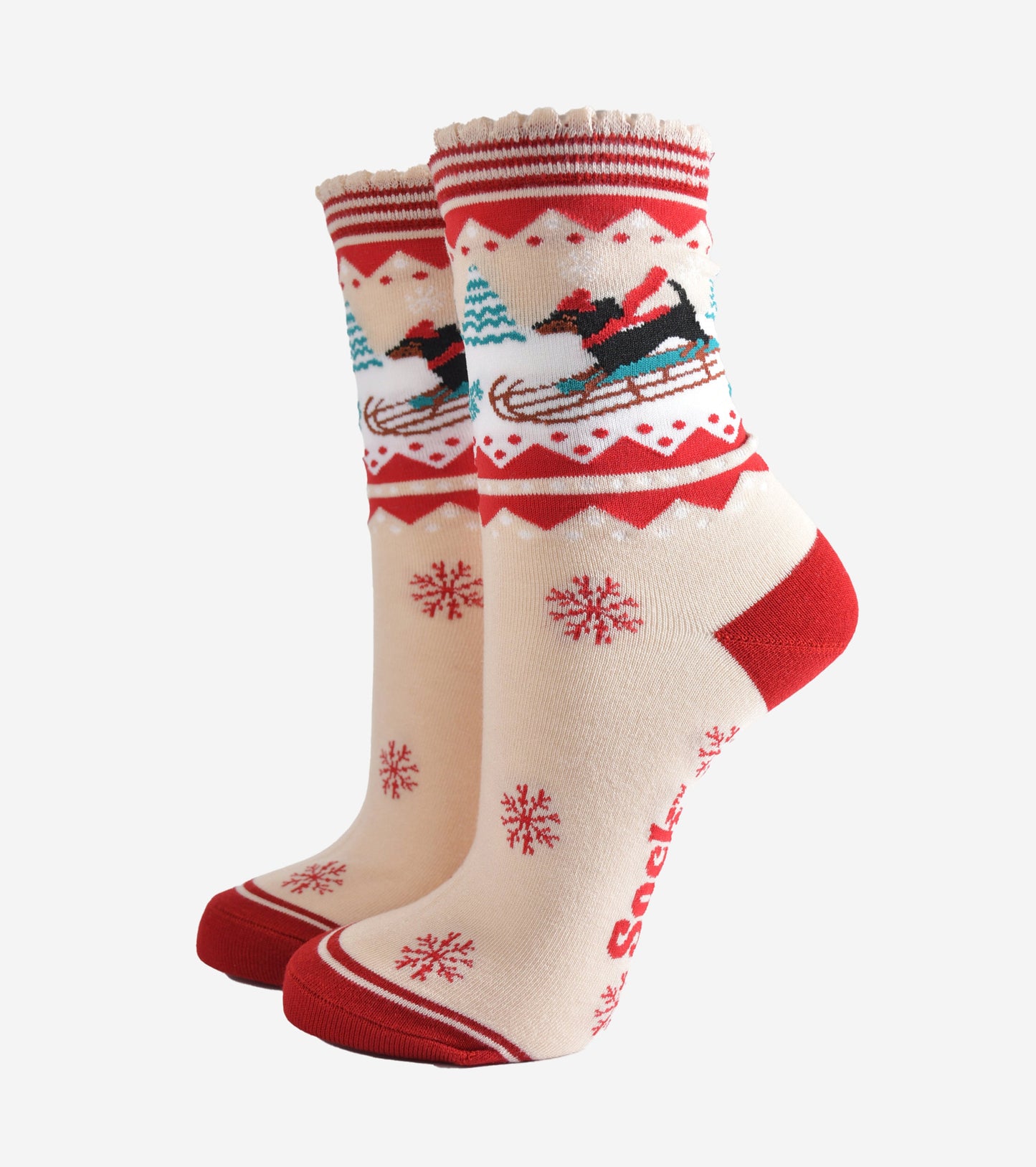 cream and red bamboo socks featuring a sledging sausage dog and red snowflake pattern