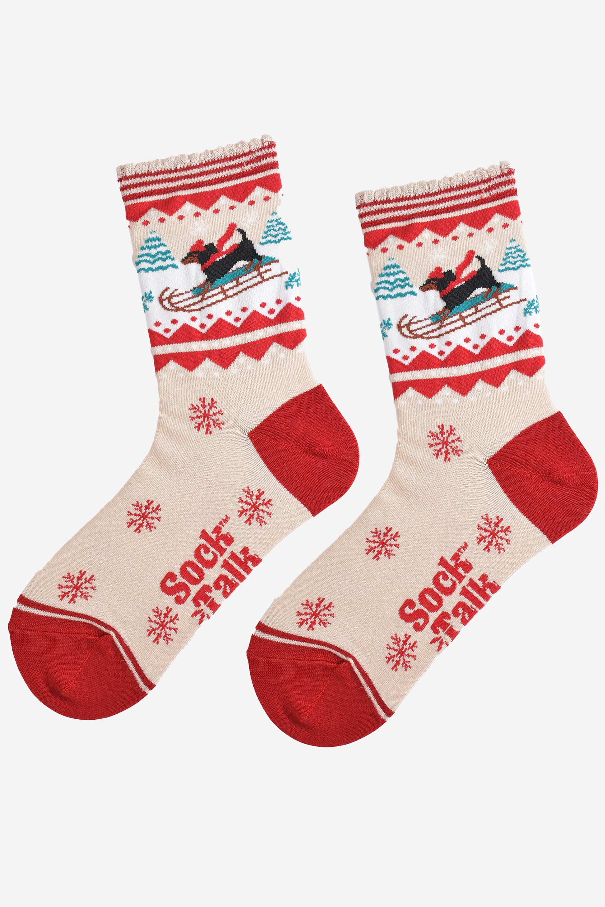 showing the sledging sausage dog socks laying flat, there is a pattern of large red snowflakes on the cream base of the socks
