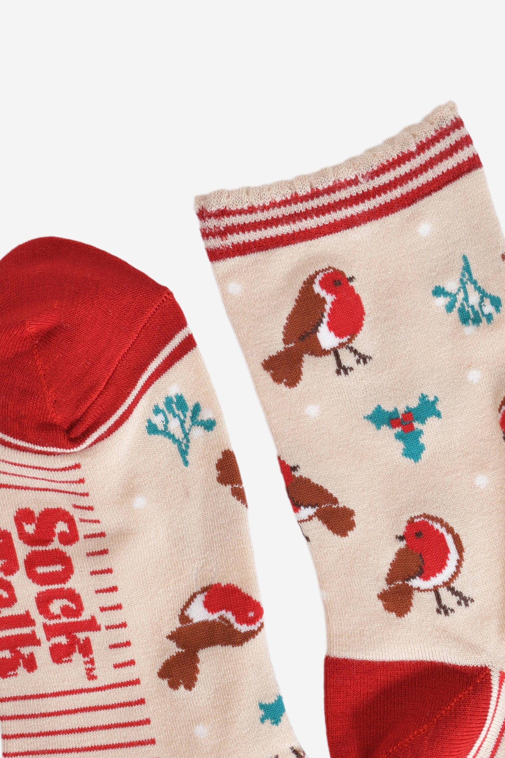 close up of the toe and cuff, the toe is red in contrast to the cream colour of the socks, the cuff is scalloped with three red horizontal stripes around the edges