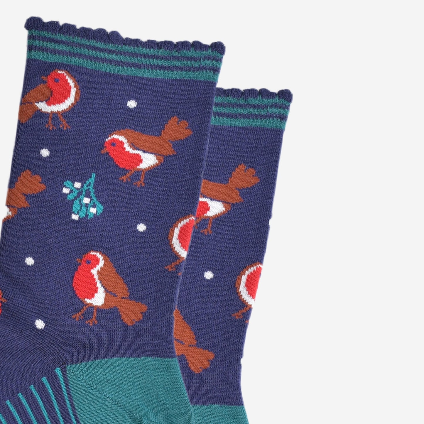 close up of the red robins and mistle toe pattern on the socks, also visible are small white dots designed to look like subtle falling snowflakes