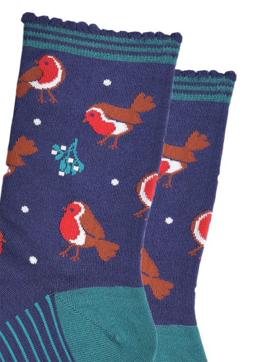 close up of the red robins and mistle toe pattern on the socks, also visible are small white dots designed to look like subtle falling snowflakes