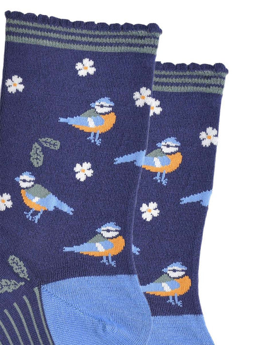 close up of the blue tit bird desgin on the socks, the birds are yellow and light blue with a blue crest on their heads, there are also green leaves and white flowers as part of the all over design