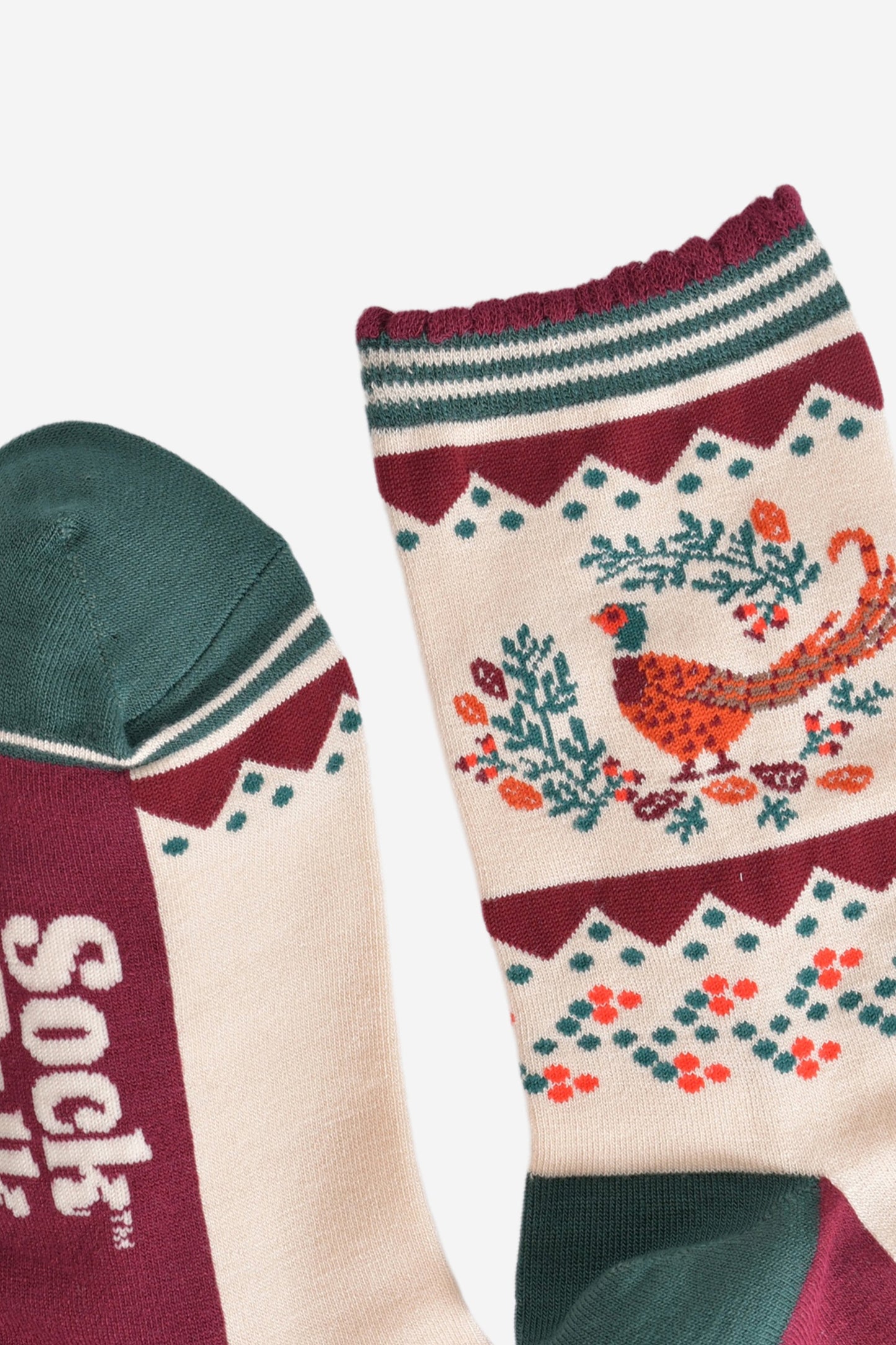 close up of the toe and cuff of the socks, the toe is green with a cream striped outline, the cuff is scalloped with a burgundy edge and green and cream striped pattern