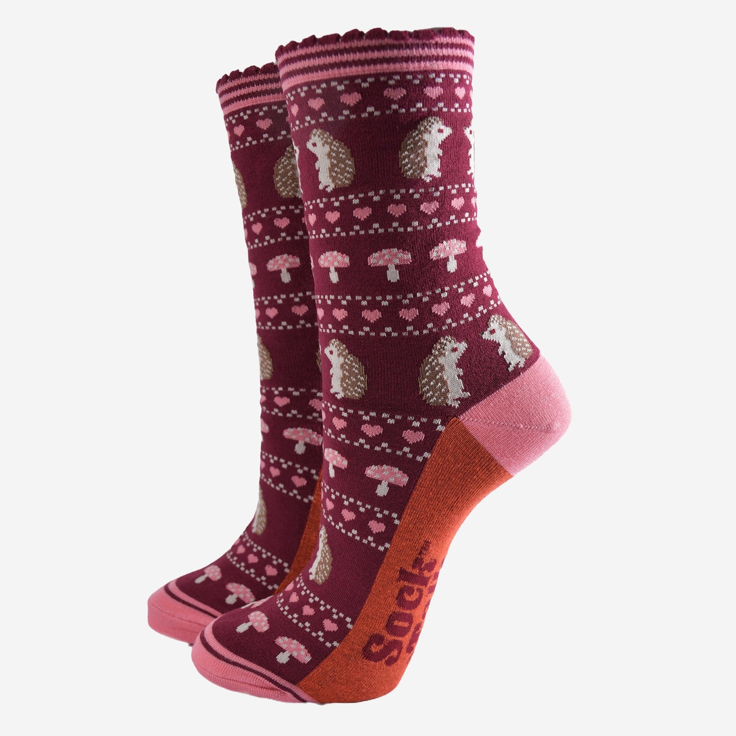 berry red bamboo socks with a pink striped cuff and an fair isle style pattern featuring hedgehogs, toadstools and pink love hearts