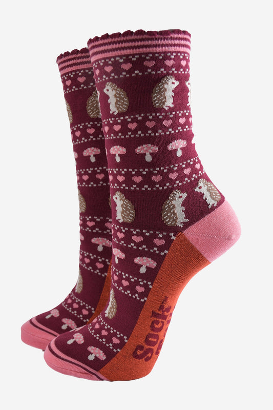 berry red bamboo socks with a pink striped cuff and an fair isle style pattern featuring hedgehogs, toadstools and pink love hearts