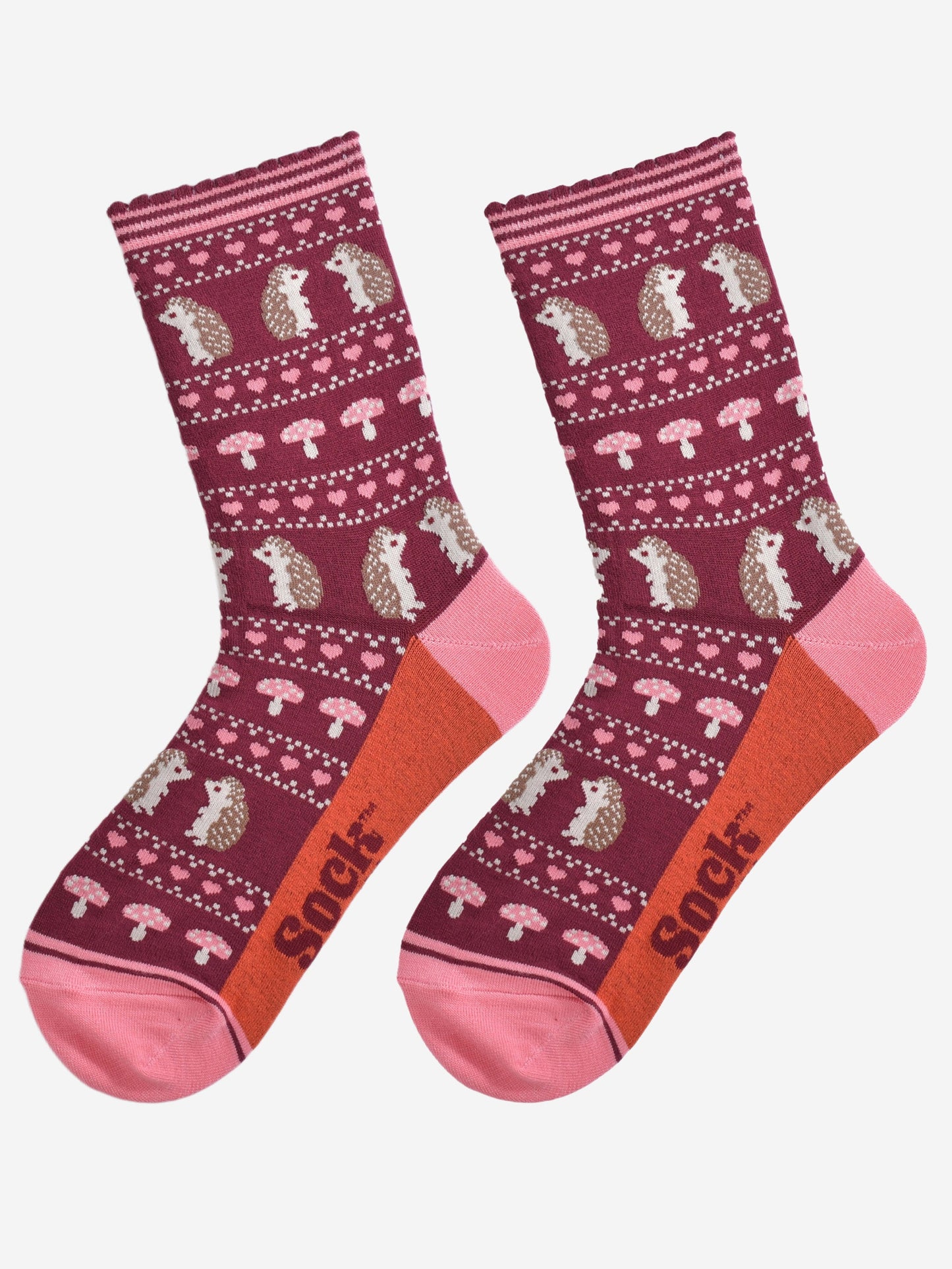 showing the fair isle hedgehog socks laying flat, highlighting the all over pattern featuring hedgehogs, toadstools and pink love hearts