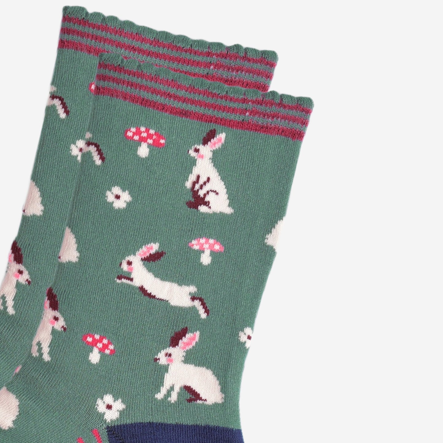 close up of the white rabbit design, the rabbits are sitting, hopping and standing, they have pink rosy cheeks and pink inner ears. there are pink and white toadstools and white flowers scattered around the design.