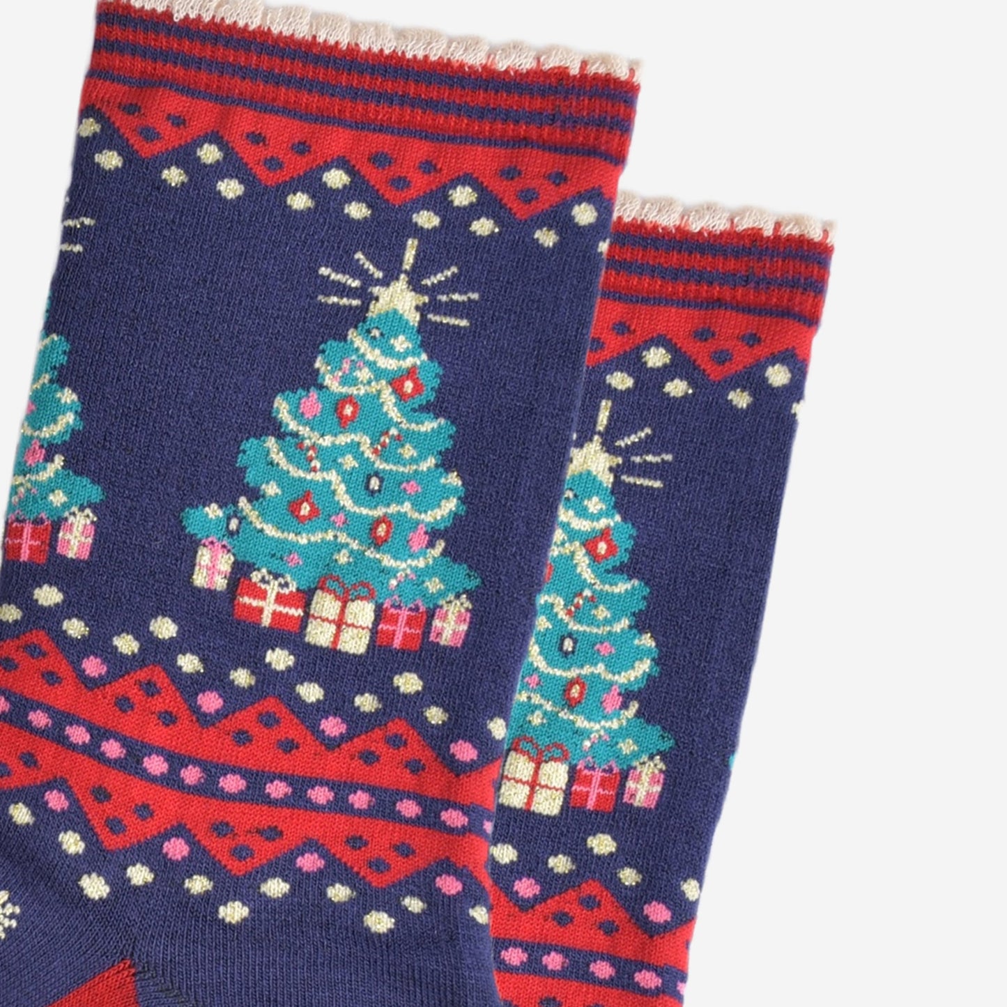 close up of the christmas tree design on the ankle of the socks, the tree is green with multicoloured baubles, gold tinsel and red candy canes. below the tree are wrapped gifts