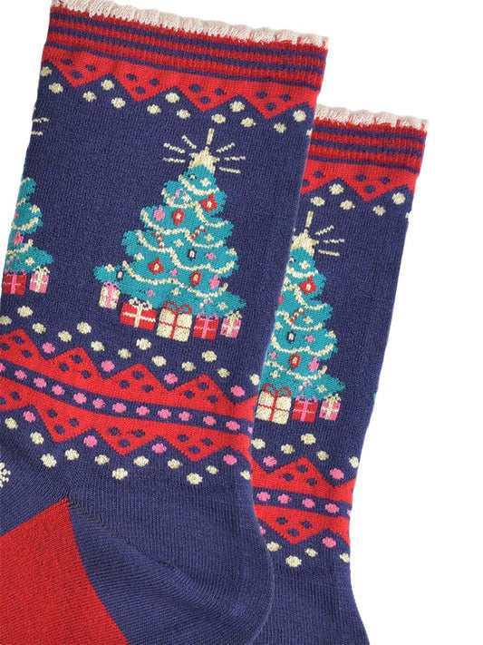 close up of the christmas tree design on the ankle of the socks, the tree is green with multicoloured baubles, gold tinsel and red candy canes. below the tree are wrapped gifts