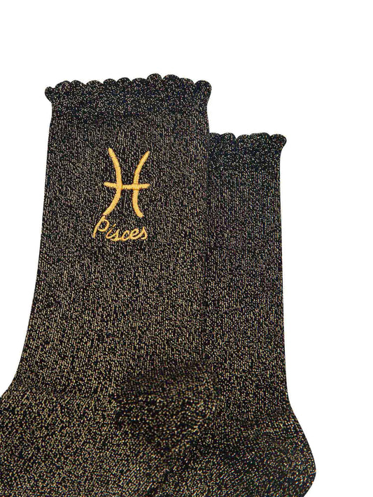 close up of the gold embroidered zodiac detail on the ankle of the socks, showing clearly the symbol of and word pisces