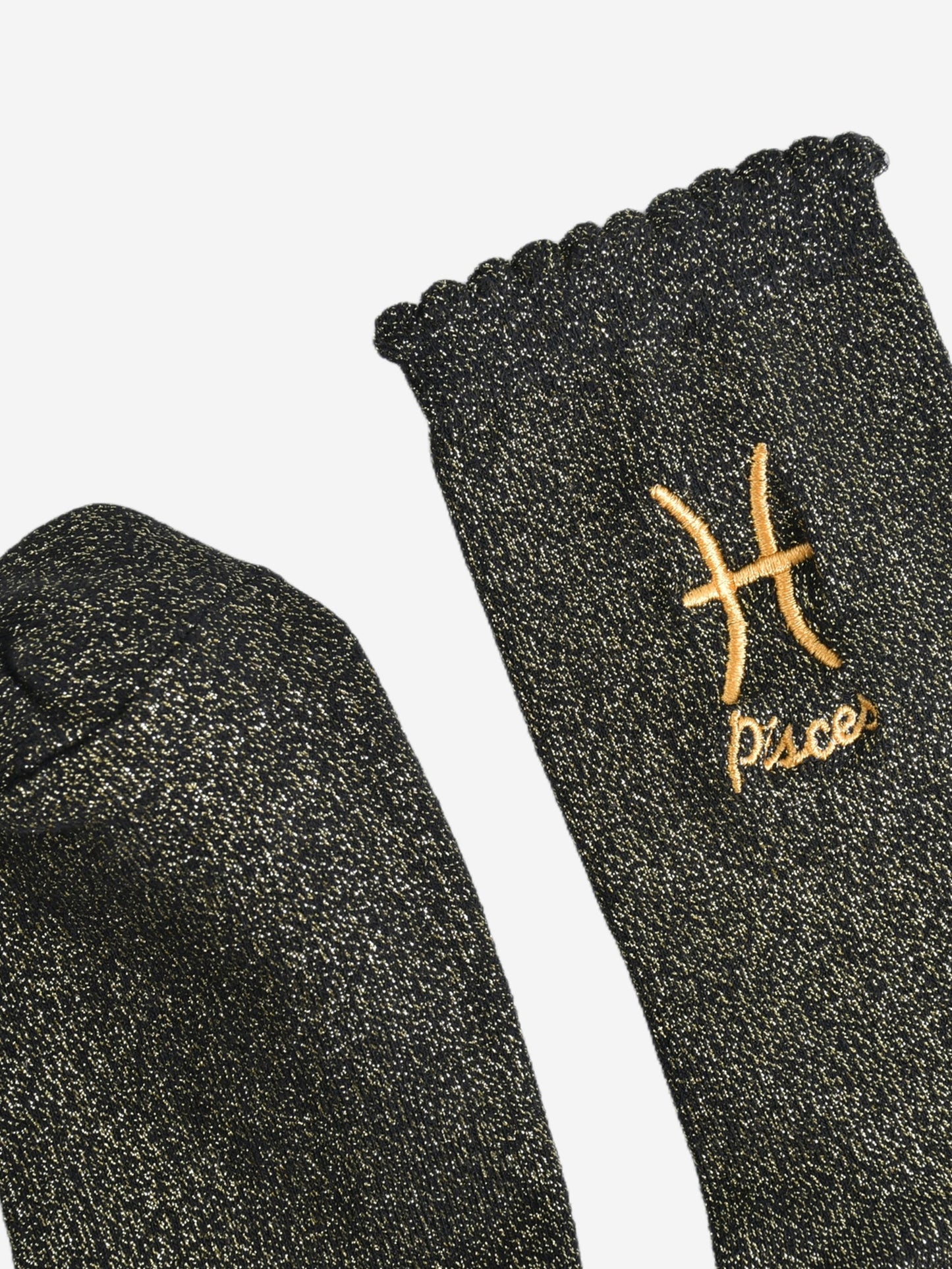 showing the toe and cuff of the socks, they are the same black and gold sparkly colour as the body of the socks, the cuff is scalloped shaped like a slight frill