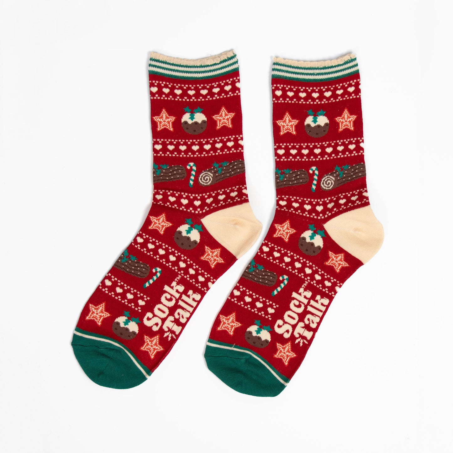 showing the christmas pudding fair isle socks laying flat. the christmas treats are in rows, separated by white dots and love hearts. The socks have a cream heel and green toe in contrast to the red background of the socks.