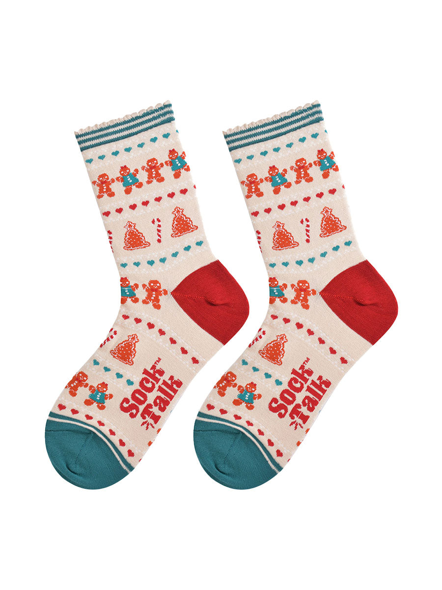 showing the festive gingerbread socks laying flat, the fair isle pattern is all over the socks and features gingerbread men, gingerbread women, gingerbread xmas tree cookies, candy canes and love hearts