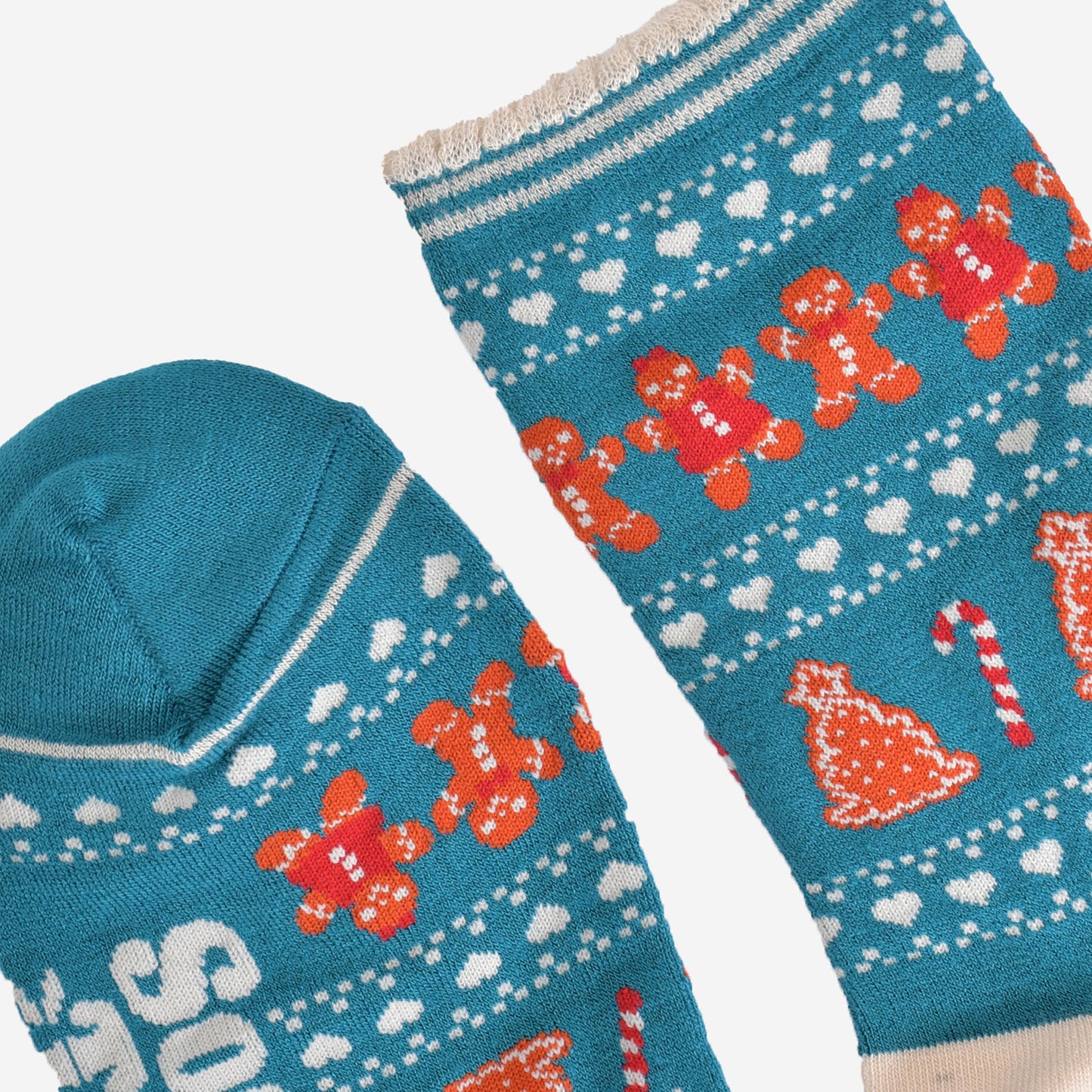close up of the toe and cuff, the toe is blue the same as the base of the socks, the cuff has a scalloped edge and has cream and blue stripes