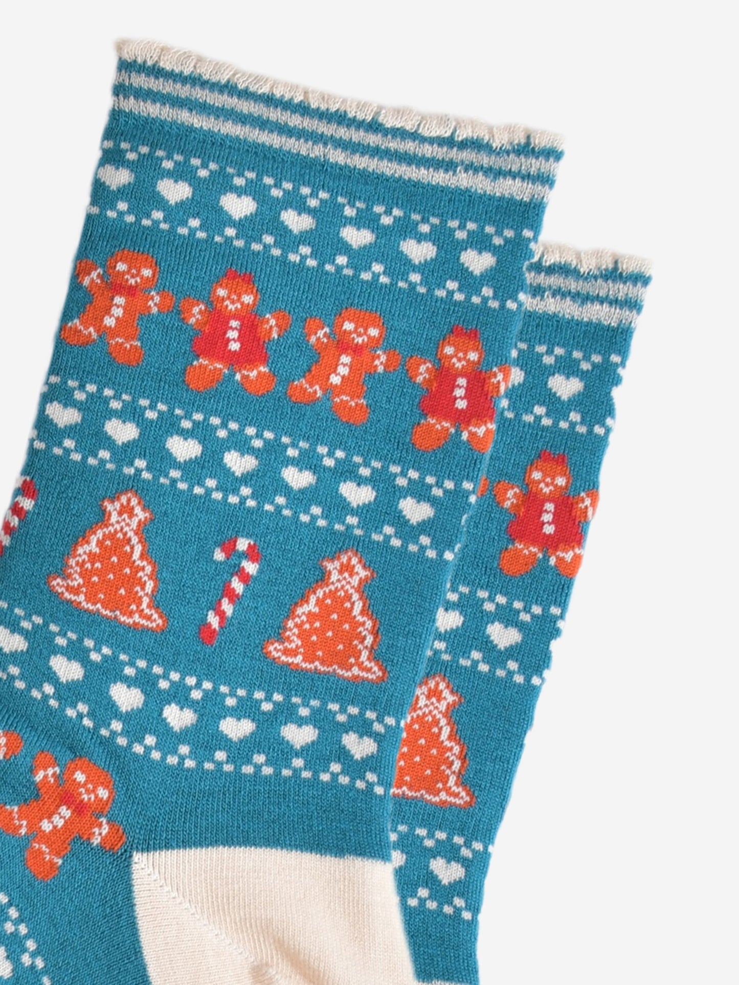 close up of the fair isle pattern, there are rows of gingerbread cookies men and women side by side, rows of white love hearts and rows of gingerbread xmas trees and candy canes.