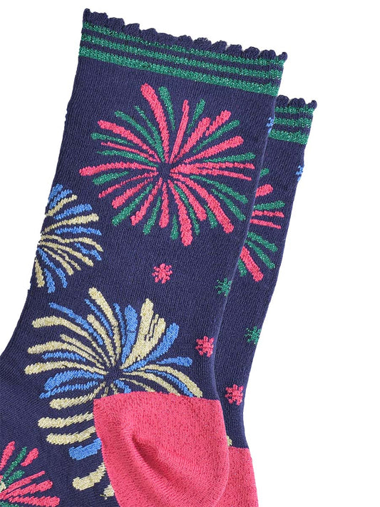close up of the sparkly fireworks on the socks, they are all in two colours and look like they are exploding in the sky. there are pink and green fireworks, blue and gold fireworks and blue and green fireworks