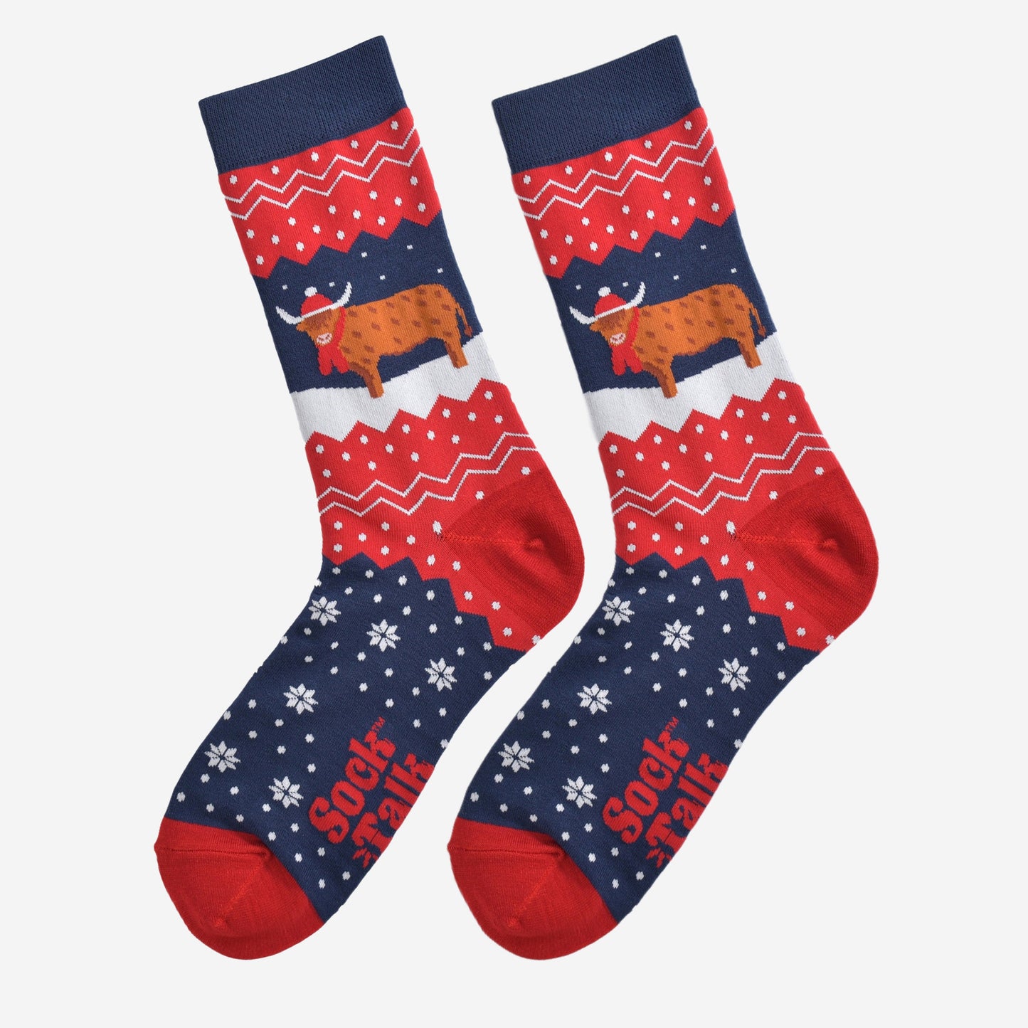 showing these red and blue fair isle pattern highland cow socks laying flat, showing the overall festive winter pattern