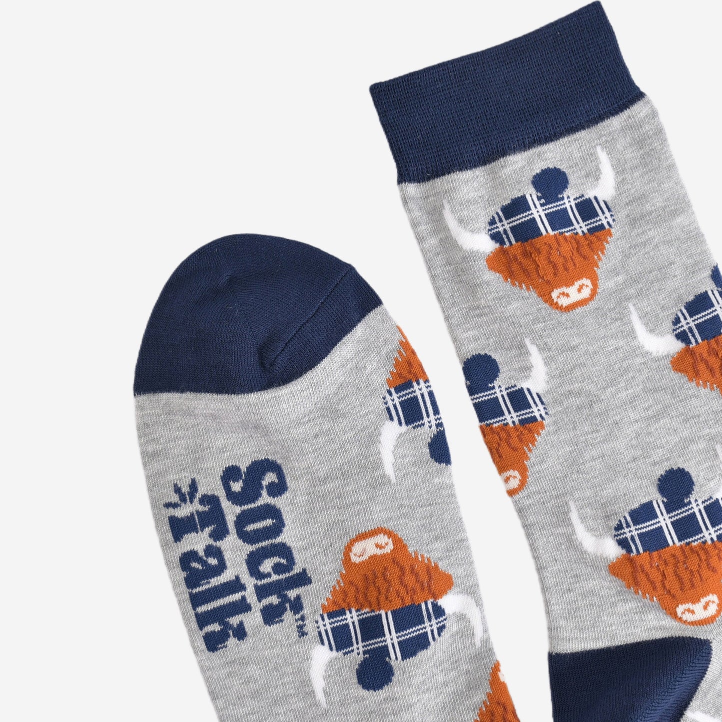showing the toe and cuff of the grey and navy blue scottish highland cow socks