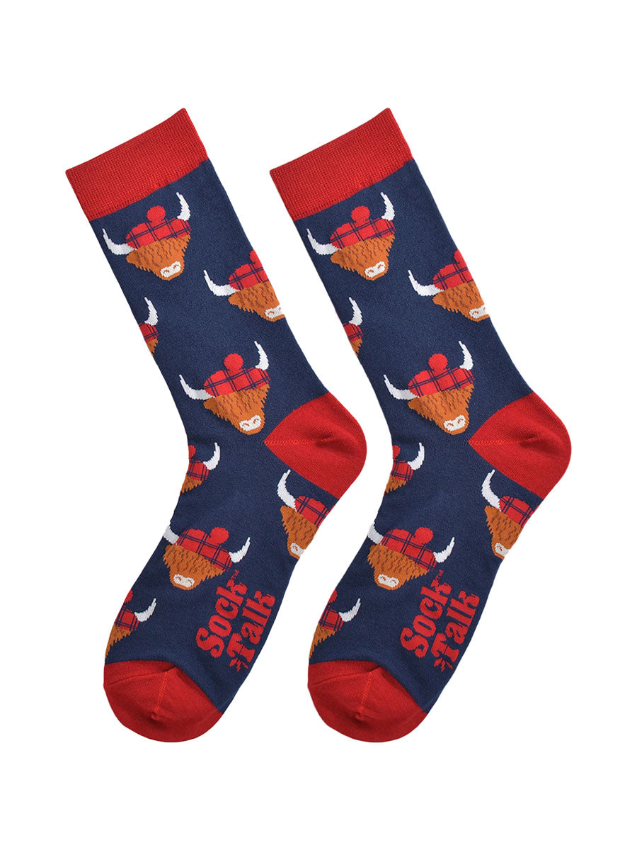 red and navy blue highland cow bamboo socks laying flat, the highland cows are wearing blue tartan hats