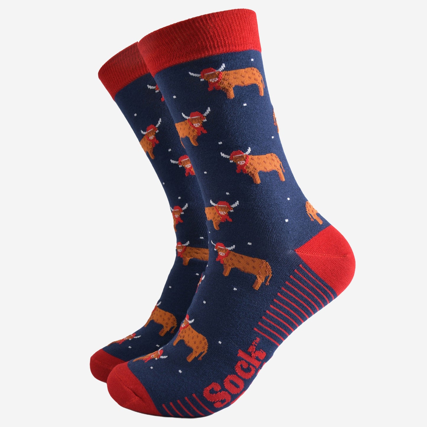 navy blue socks with a red heel, toe and trim with an all over pattern of highland cows wearing santa hats and winter scarves