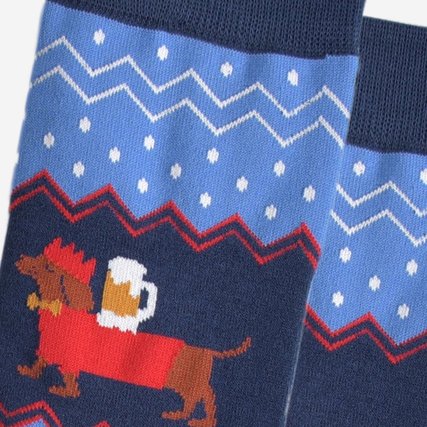 close up of the sausage dog, showing clearly that it is balancing a full pint of beer on its back, the dog is also wearing festive red jumper and red party hat