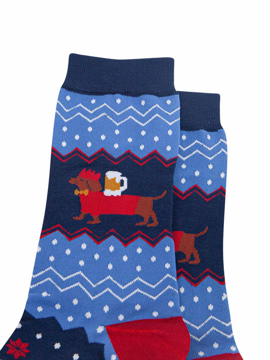 close up of the sausage dog, showing clearly that it is balancing a full pint of beer on its back, the dog is also wearing festive red jumper and red party hat