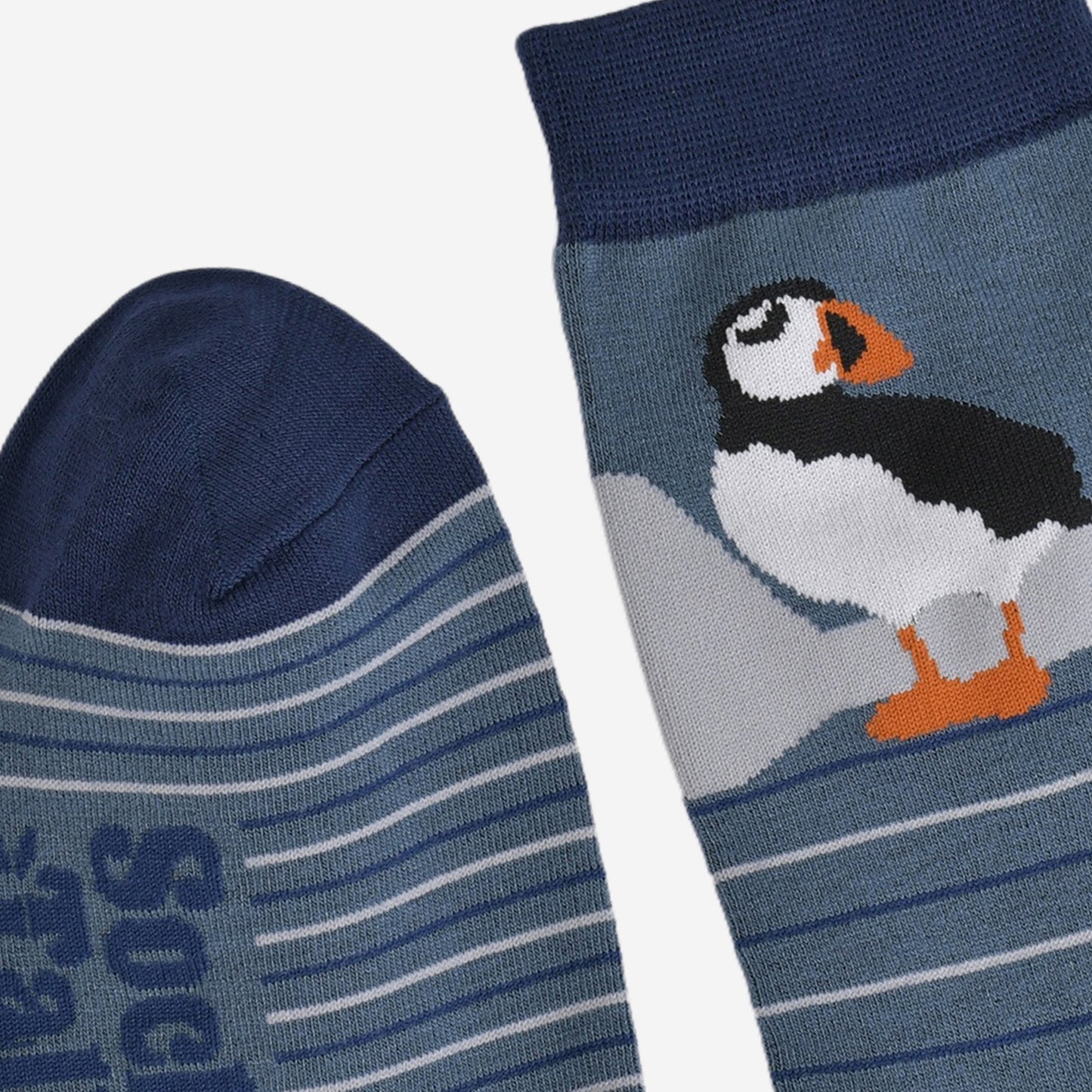 close up of the toe and cuff, both are navy blue in contrast to the teal blue background of the socks
