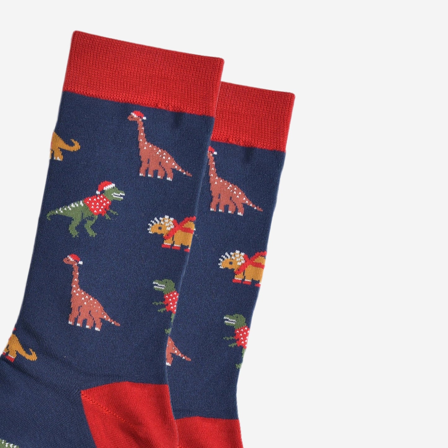 close up of the dinosaur design on the socks, t-rex, triceratops and brontosaurus are all wearing festive attire, santa hats and jumpers
